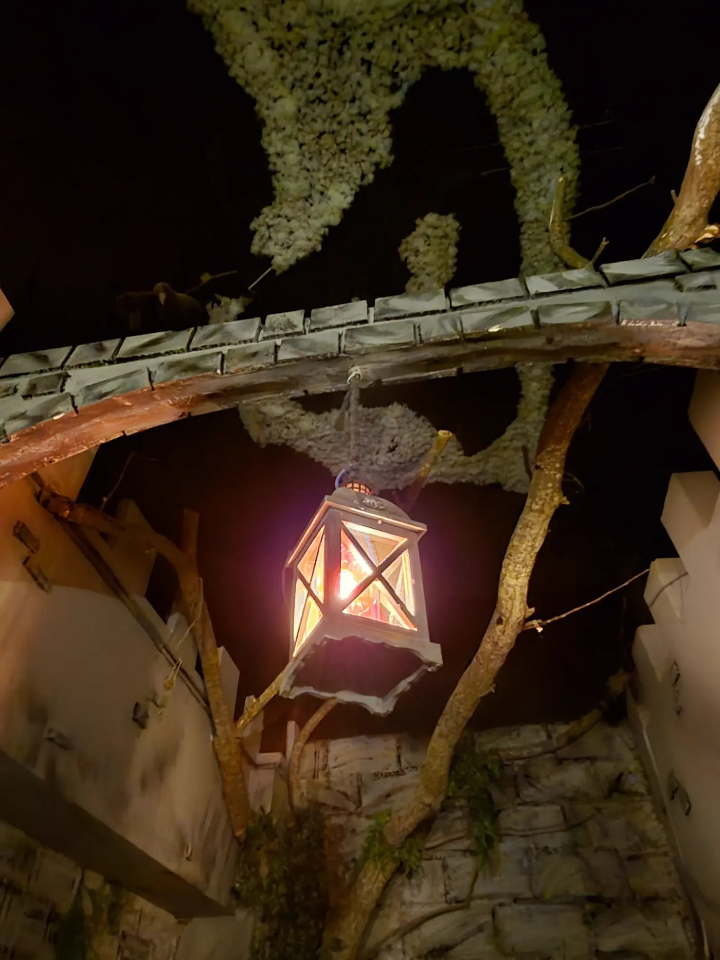 Farolillo encendido entre vigas y musgo del Castillo de Bran